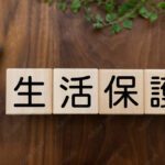 高齢者の生活保護。木製のブロックに「生活保護」の文字が書かれたイラスト